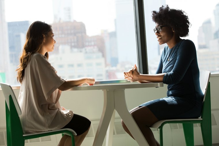 Two colleagues seated at a table during a mentoring session